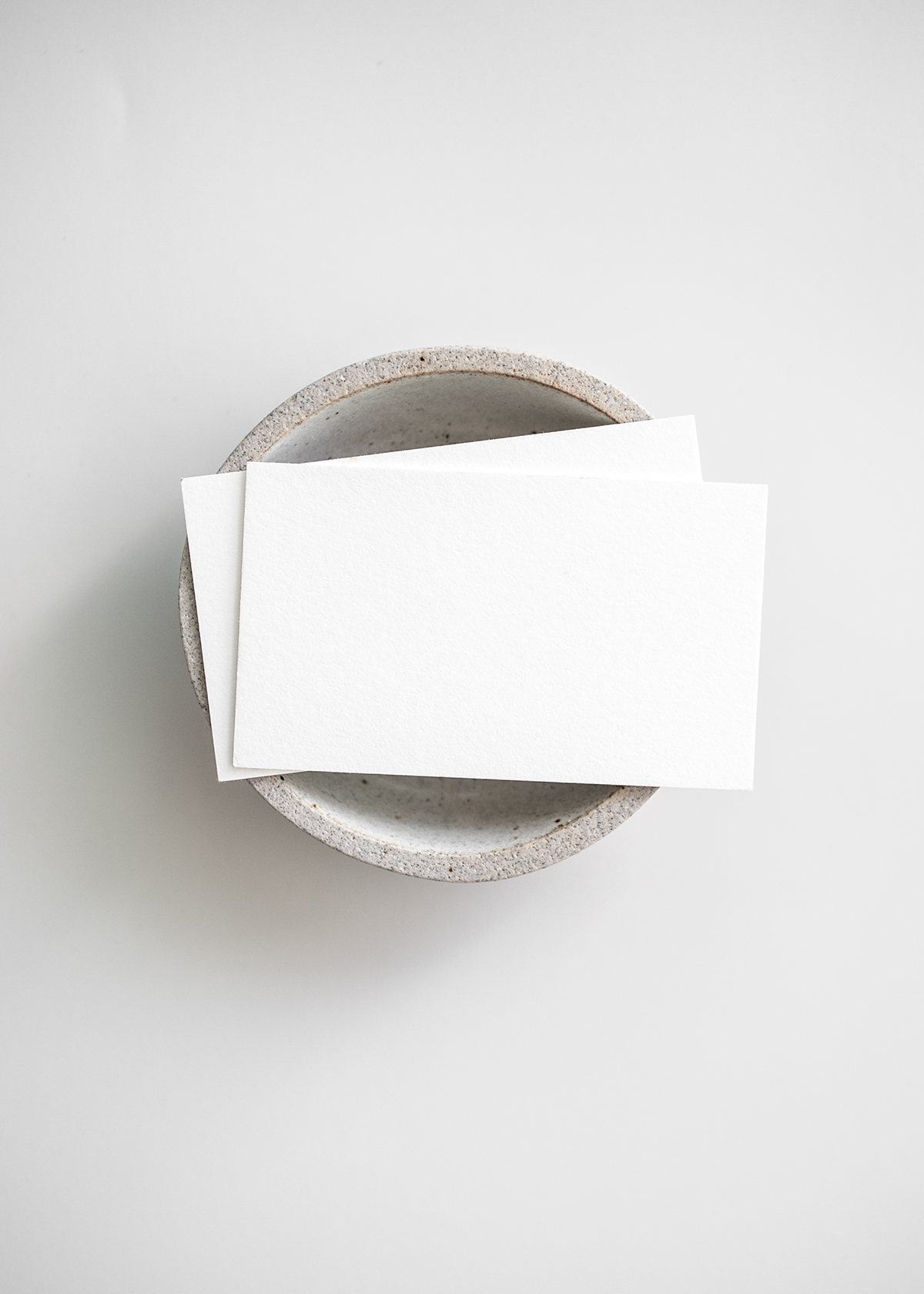 Stack of blank white paper sheets on a round gray stone surface
