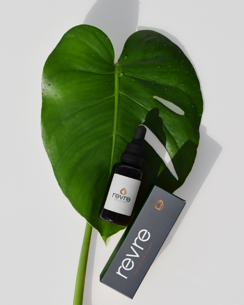 Product photo with tropical leaves, serum bottle, and branded packaging for Launch Assets section