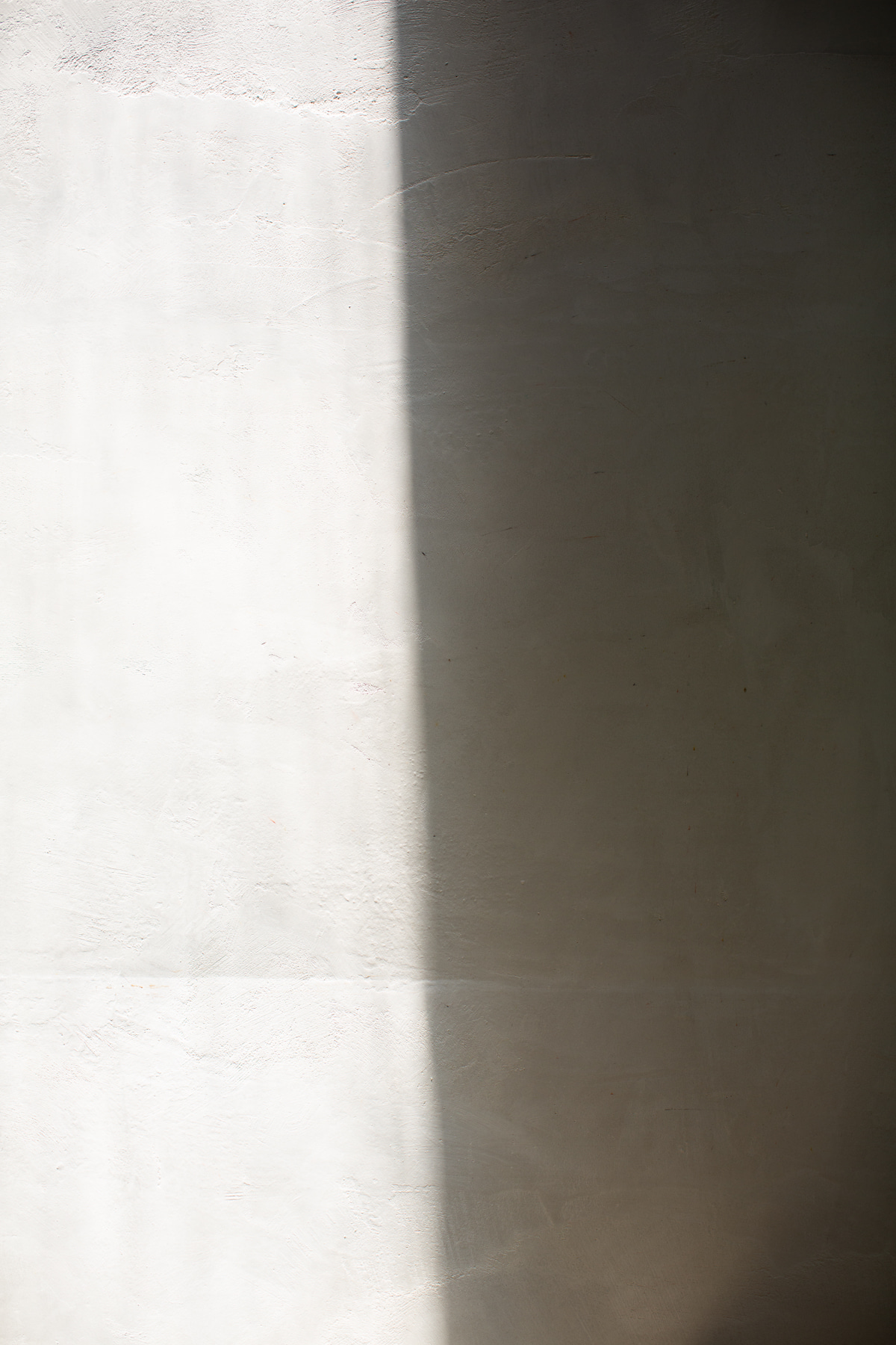 Textured plaster wall with soft light and shadow